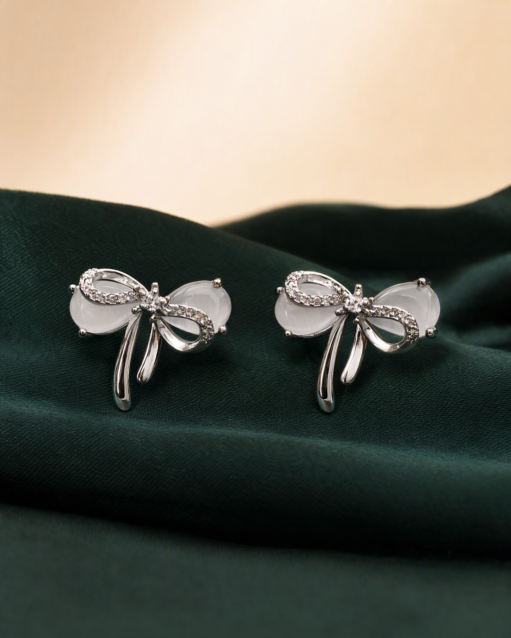 Silver bow stud earrings portrait product view